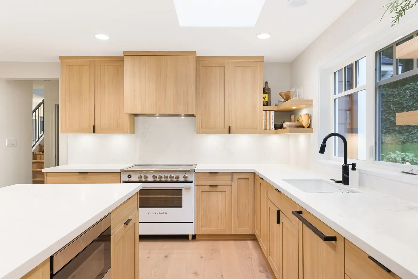 A finished white-oak kitchen seen from the dining room