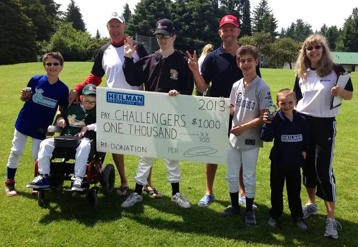 Challenger baseball players holding a Heilman Renovations cheque
