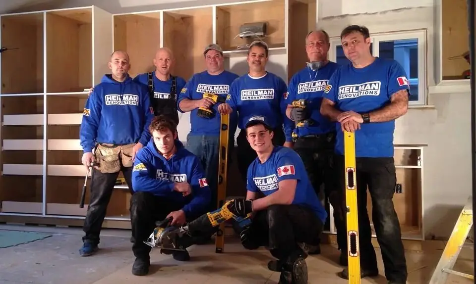 Seven Heilman crew members in blue shirts in front of new built-in cabinetry