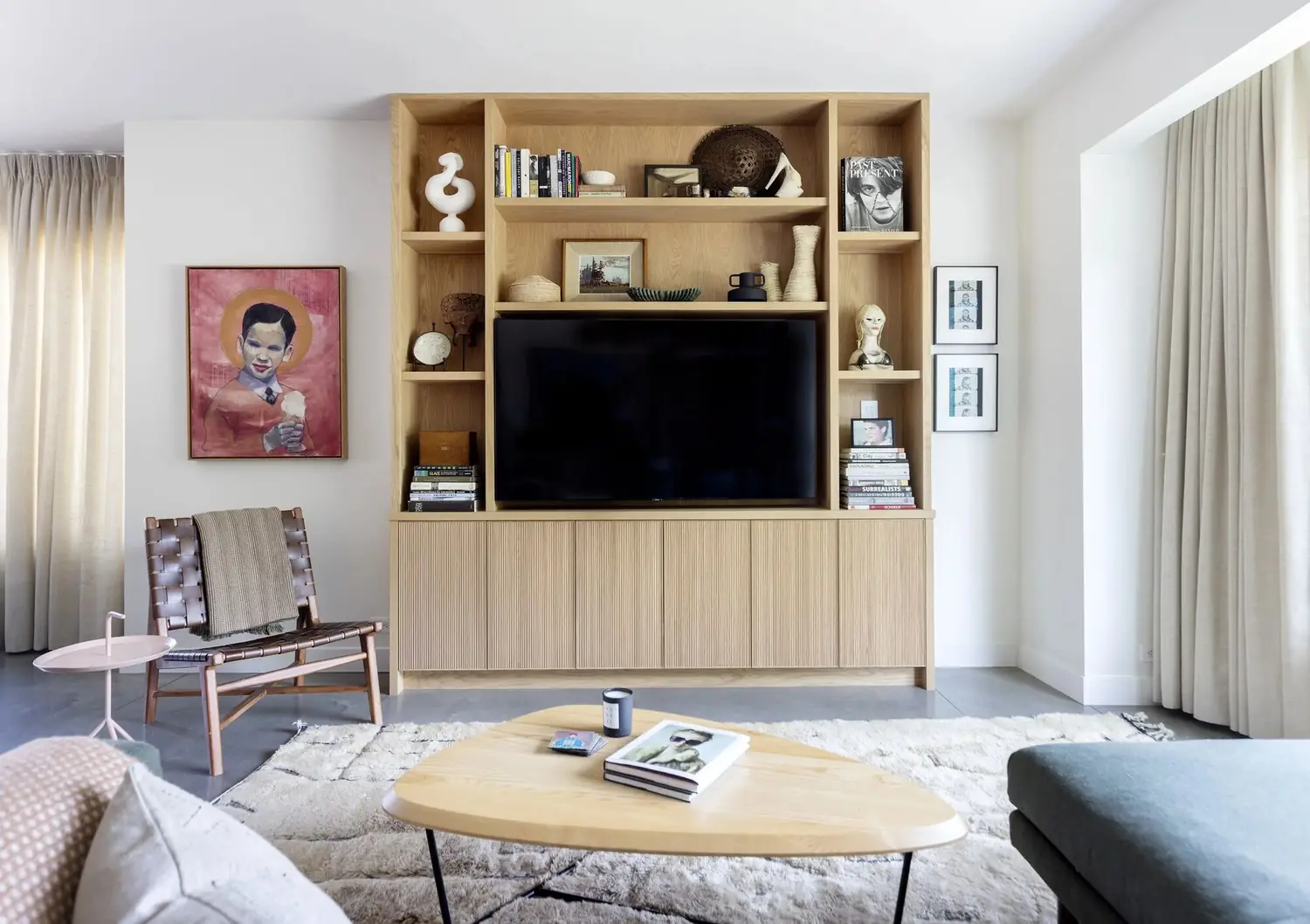 Living room with a built-in oak shelving wall around the TV