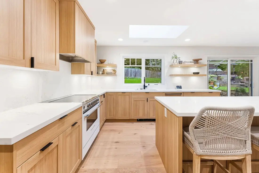 Finished white-oak kitchen with an island and woven counter stools